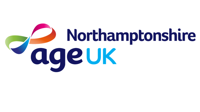 A support worker sits with a older person reading a book